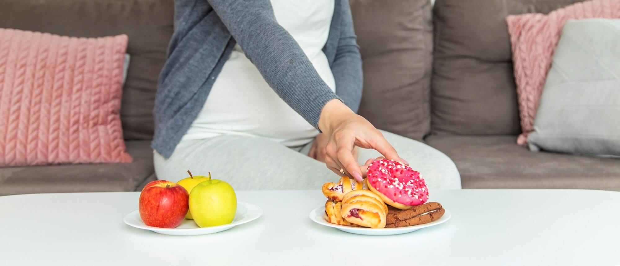 A pregnant woman eats a sweet donut. Selective focus.