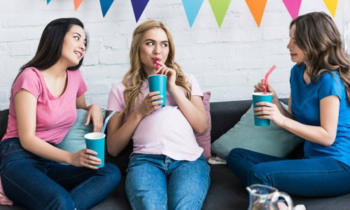 multicultural friends and pregnant woman drinking at baby-party