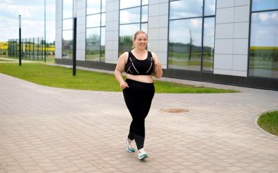 Obese woman in a tracksuit does a morning jog