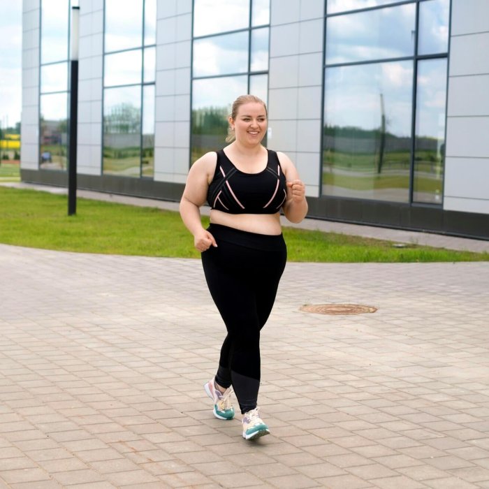 Obese woman in a tracksuit does a morning jog