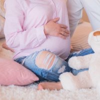 Pregnant couple expecting baby. Pregnant woman holds hands on belly. Pregnancy, maternity