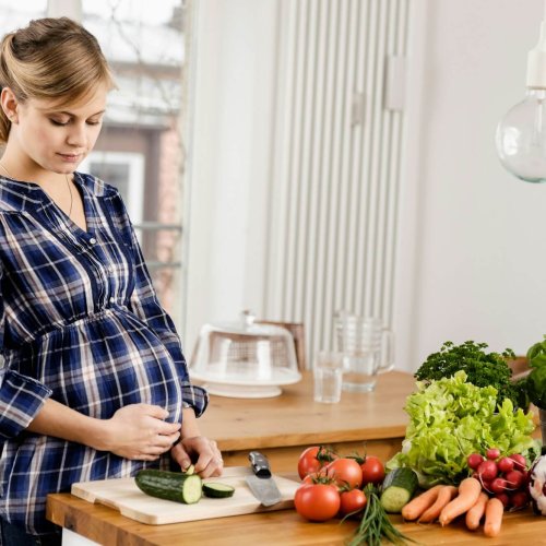 Pregnant woman chopping vegetables